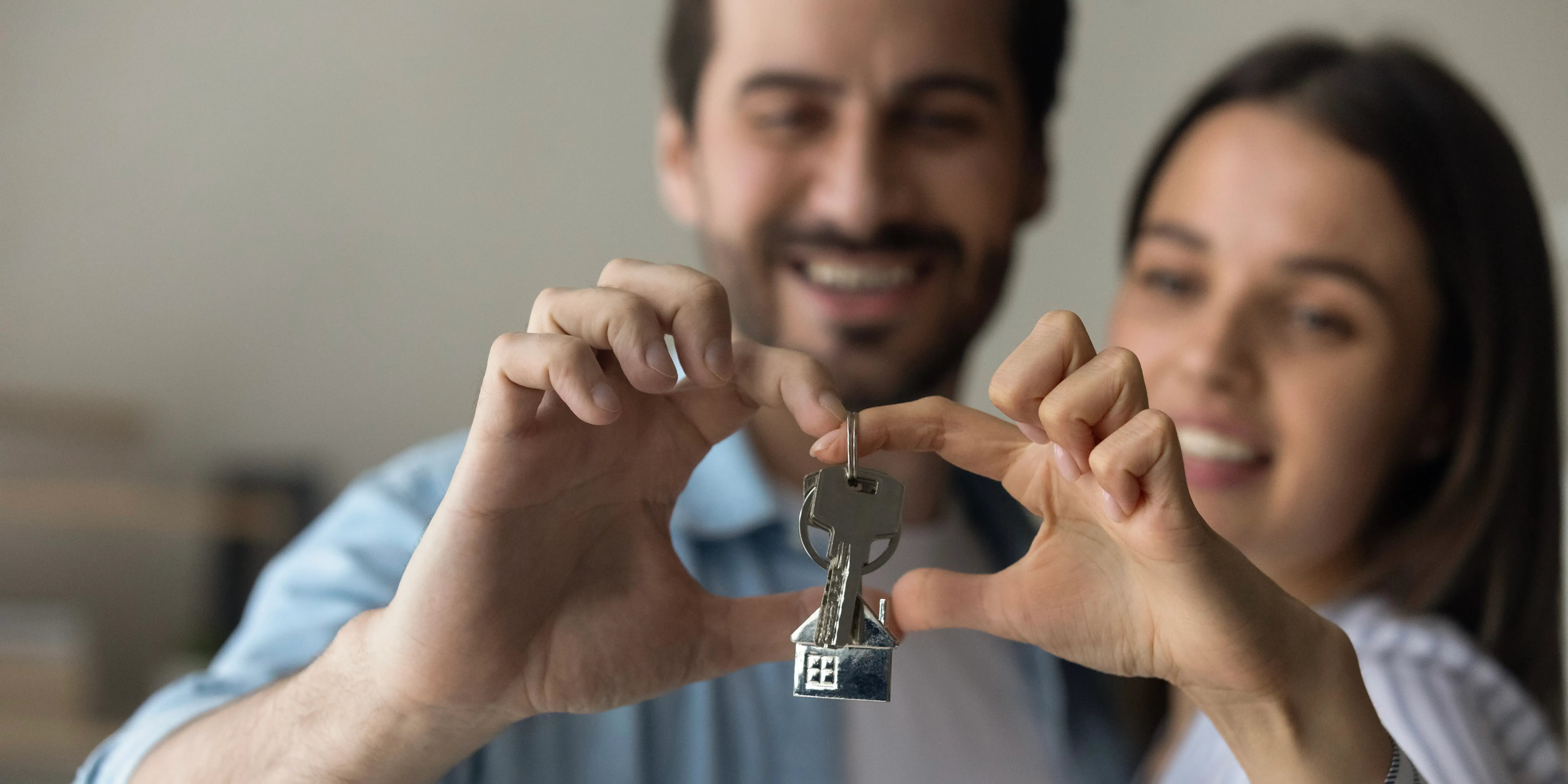 Pareja sosteniendo las llaves de su nueva casa que compraron con el crédito Infonavit Unamos créditos